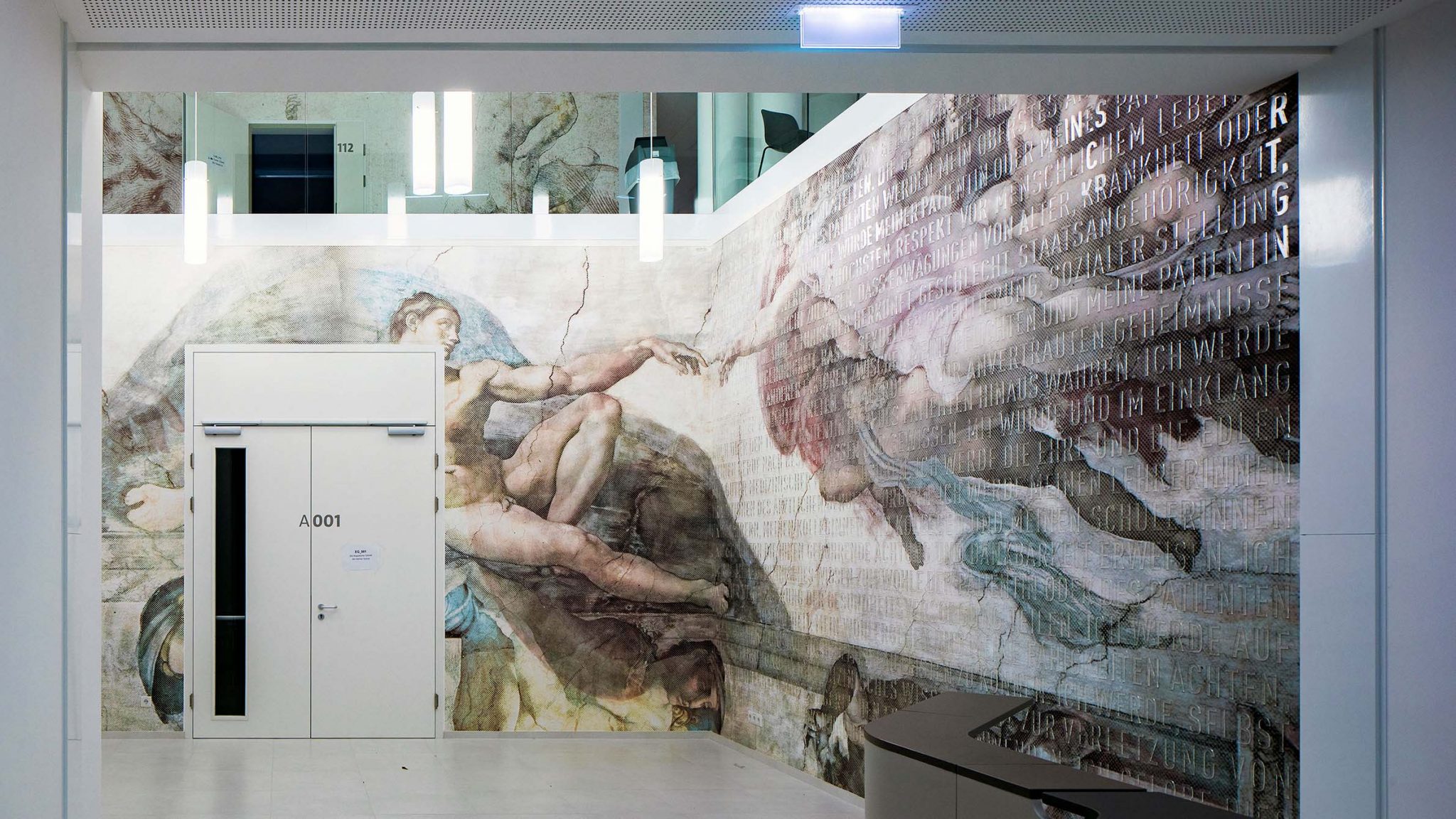Foyer der SFU mit Tapete mit neu interpretiertem Motiv der “Erschaffung des Adam” mit Genfer-Gelöbnis in durchsichtigen, auf die Wand geklebten Lettern